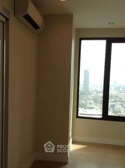 Modern apartment interior with large window offering city view and air conditioning unit.