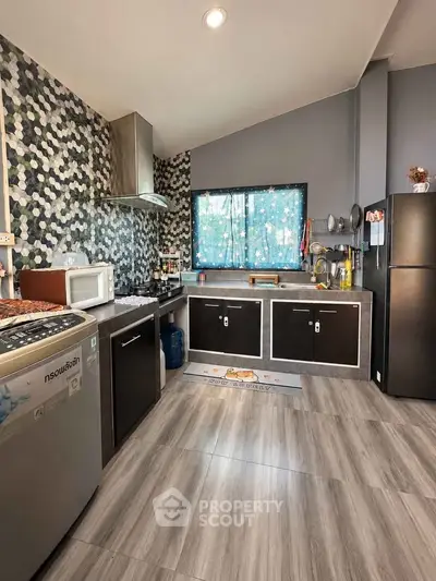 Modern kitchen with sleek cabinets and stylish backsplash in a contemporary home.