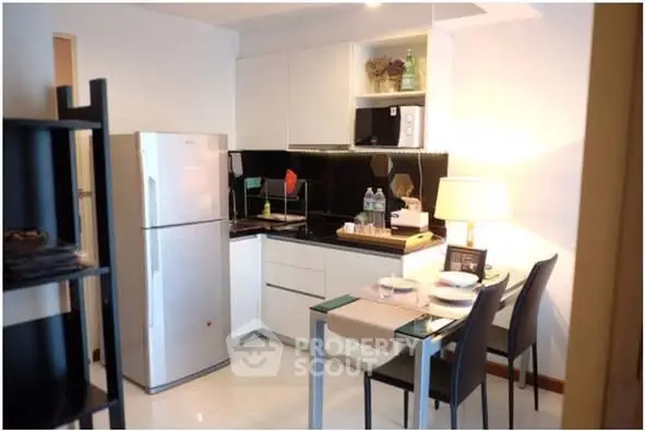 Modern kitchen with dining area, featuring sleek appliances and stylish decor.