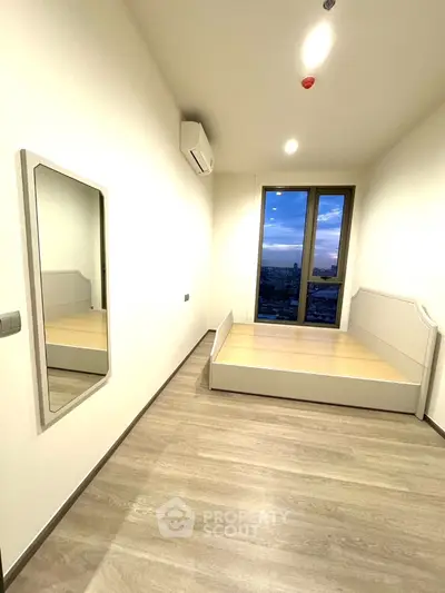 Modern minimalist bedroom with large window and city view