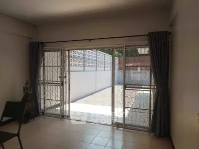 Spacious living room with sliding glass doors leading to a private outdoor area, perfect for relaxation.