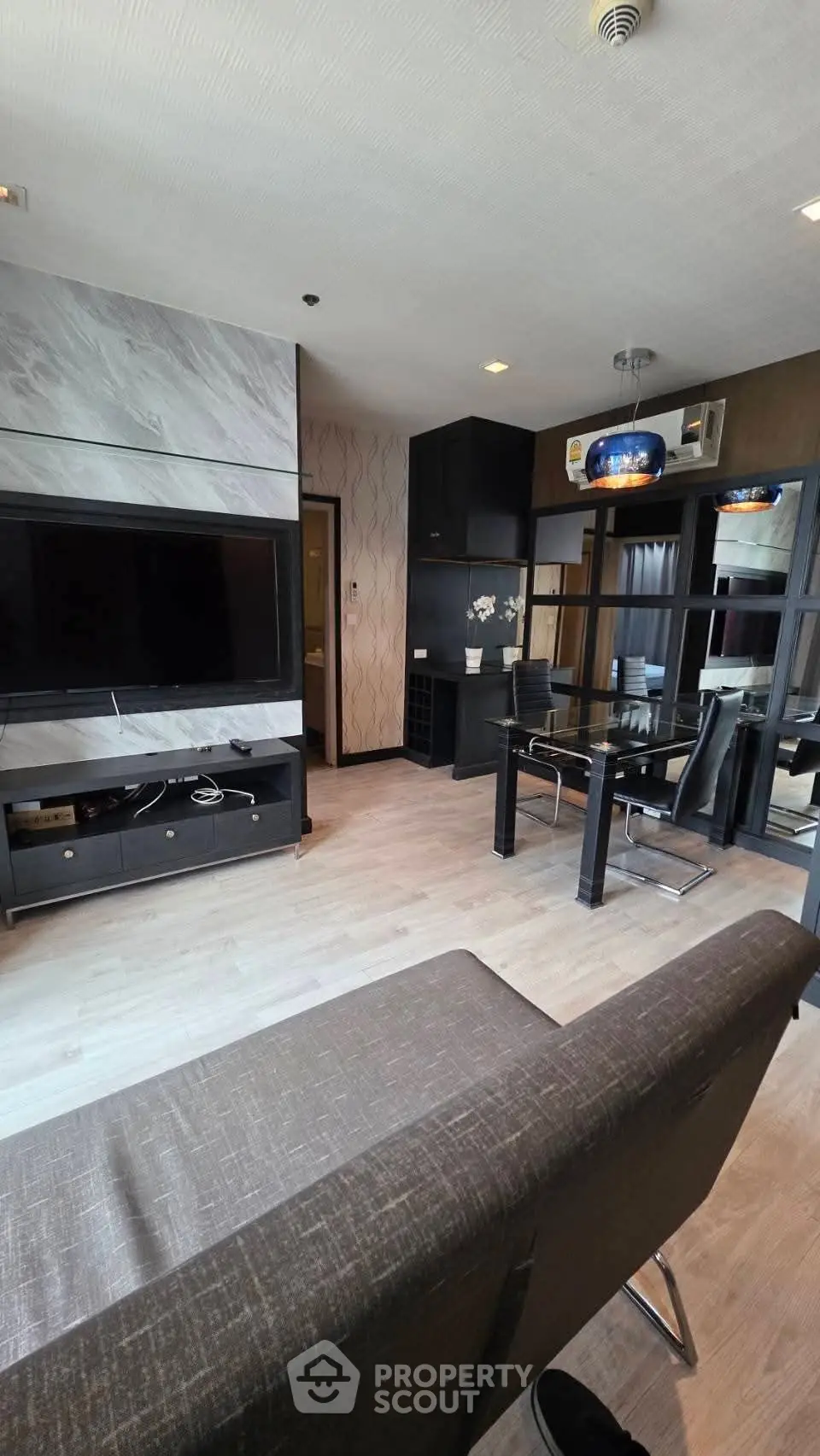 Modern living room with sleek furniture and open dining area, perfect for urban living.