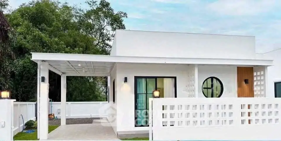 Modern minimalist white house with sleek design and lush greenery