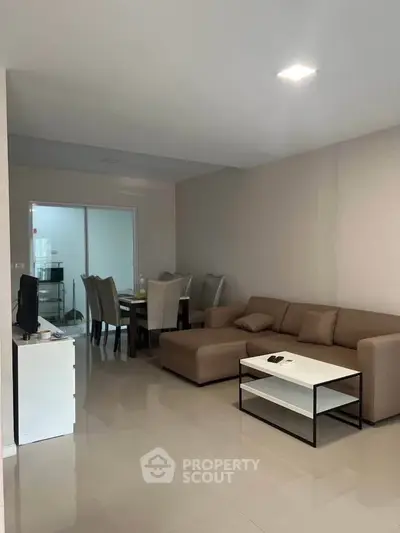 Spacious living room with modern furniture and dining area in open layout.