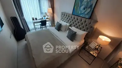 Luxurious bedroom with elegant decor and natural light, featuring a plush bed and stylish workspace.