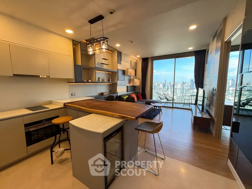 Modern open-layout kitchen and living room with city view from large windows.