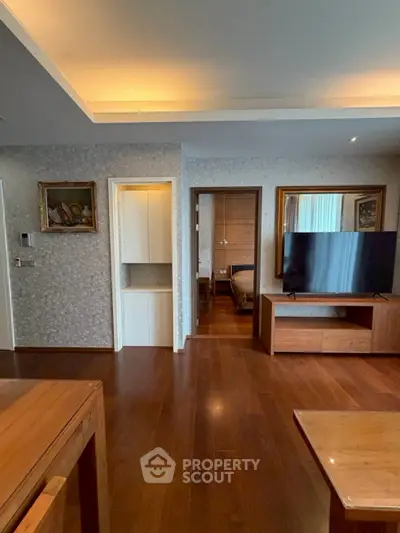 Spacious living room with wooden flooring and modern decor in a stylish apartment.