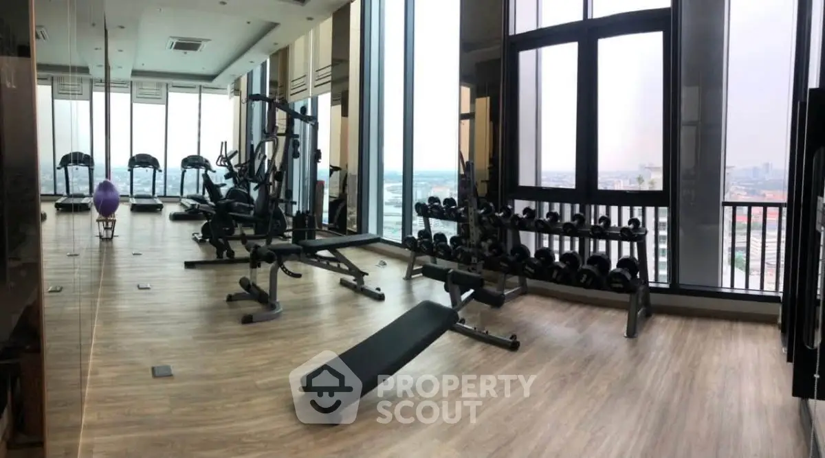 Spacious modern gym with panoramic city views and state-of-the-art fitness equipment.