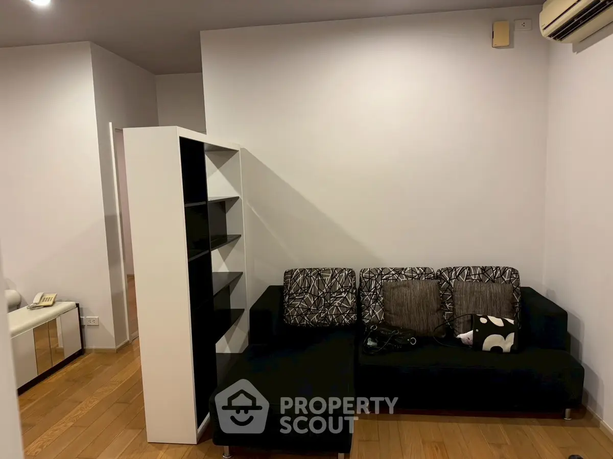 Modern living room with stylish black sofa and wooden flooring