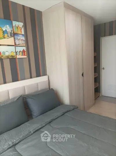 Modern bedroom with stylish decor and cozy bedding in a contemporary apartment.