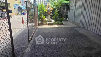 Charming gated entrance with lush greenery and decorative elements, perfect for a serene urban retreat.