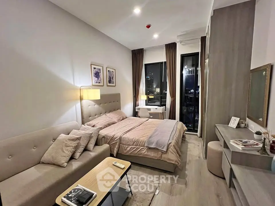 Modern bedroom with stylish decor and city view, featuring cozy lighting and elegant furnishings.