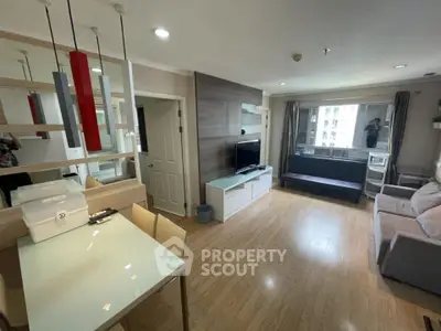 Modern living room with stylish decor, wooden flooring, and ample natural light in a cozy apartment.