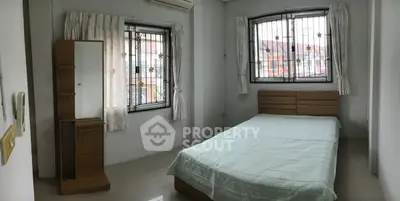Cozy bedroom with natural light, featuring a comfortable bed and stylish wooden furniture.