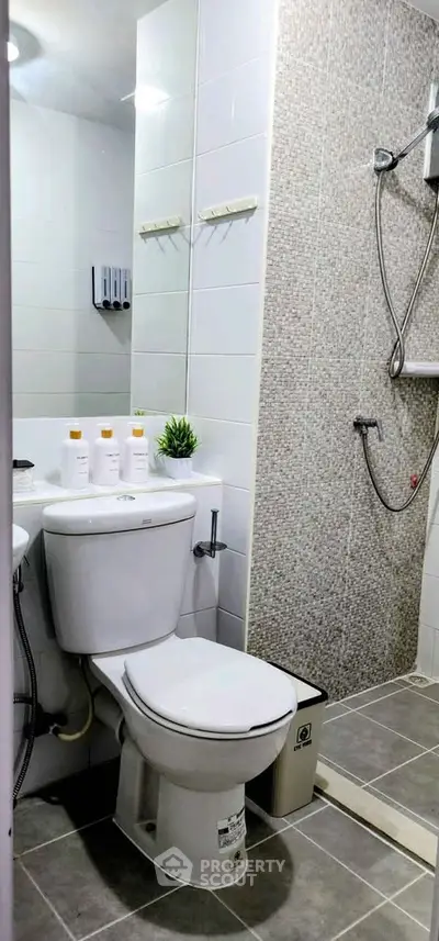Modern bathroom with shower and toilet in sleek white and gray design.