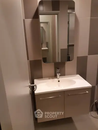 Modern bathroom with sleek vanity and mirror in contemporary apartment.