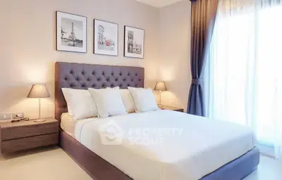 Elegant bedroom with plush bed, stylish lamps, and large window for natural light.
