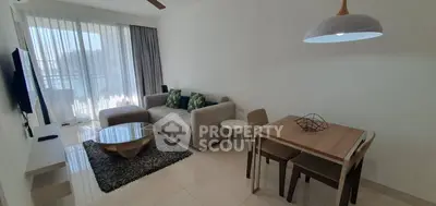 Modern living room with stylish furniture and natural light, featuring a cozy sofa and dining area.