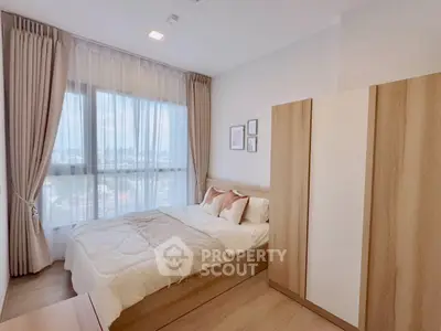 Modern bedroom with large window and stylish decor in a high-rise apartment.