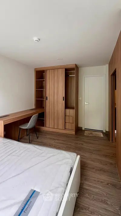 Spacious bedroom with modern wooden furniture and ample storage space