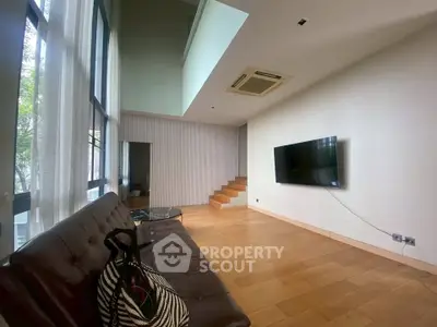 Spacious modern living room with high ceiling and large windows