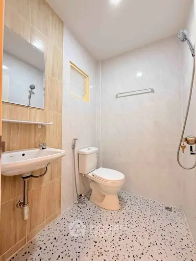 Modern bathroom with sleek fixtures and terrazzo flooring in a contemporary home.