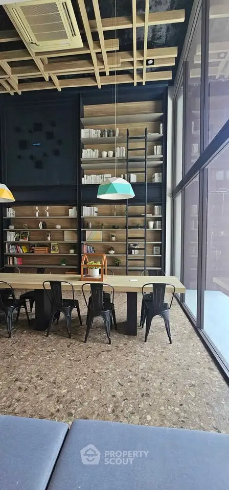 Modern co-working space with floor-to-ceiling windows and stylish shelving.