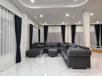 Spacious modern living room with elegant gray sectional sofa and sleek white tile flooring.