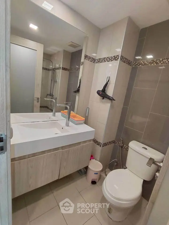 Modern bathroom with dual sinks and stylish tile accents in a contemporary apartment.