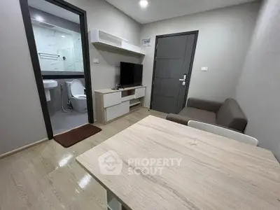 Modern compact living room with adjacent bathroom in a stylish apartment