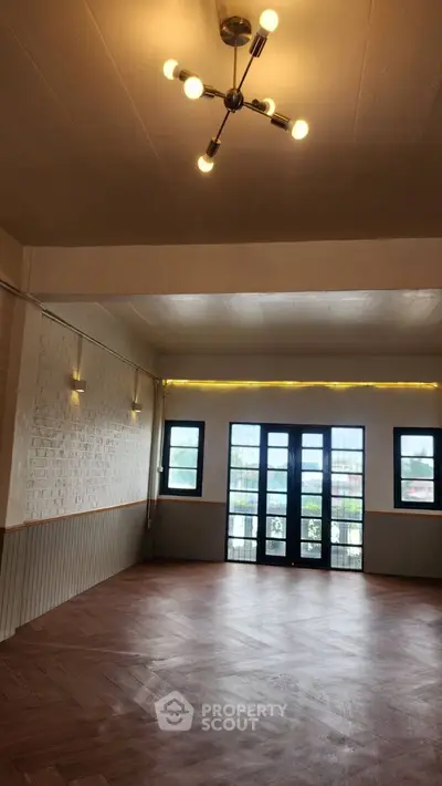 Spacious living room with elegant lighting and large windows for natural light.