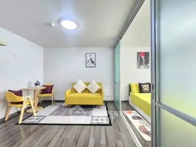 Modern living room with stylish decor and sliding glass doors leading to a cozy bedroom.