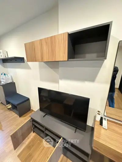 Modern living room with sleek TV unit and wooden cabinets, perfect for contemporary homes.