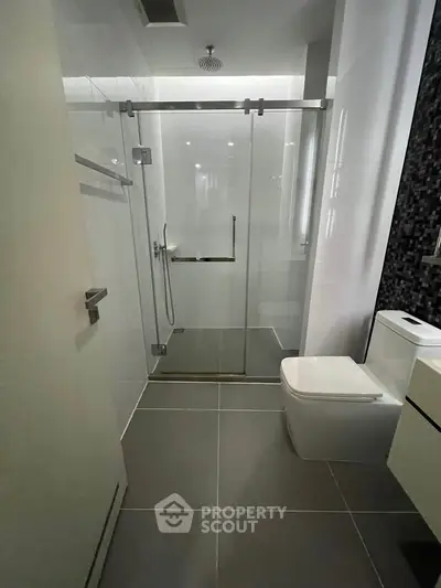 Modern bathroom with sleek glass shower and contemporary fixtures.