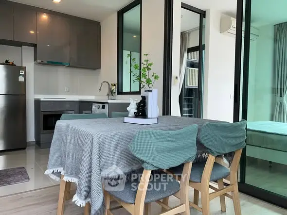 Modern dining area with stylish kitchen and open layout in contemporary apartment.