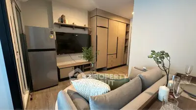 Modern living room with sleek furniture and open layout, featuring a large TV and stylish decor.