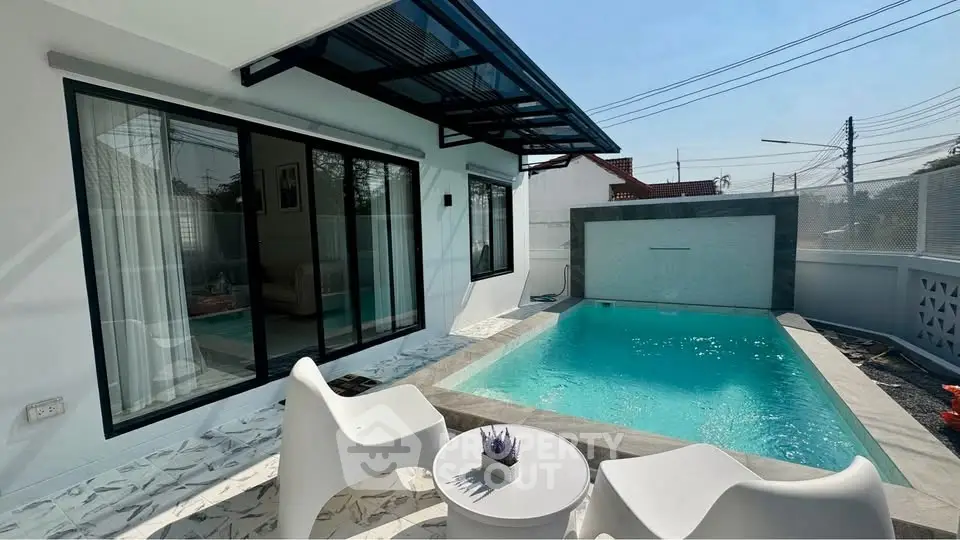 Modern home with private pool and stylish outdoor seating area.