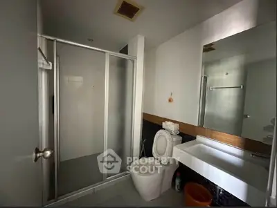 Modern bathroom with glass shower and sleek fixtures in a contemporary home.