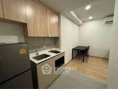 Modern kitchen with sleek cabinetry and dining area in a stylish apartment.