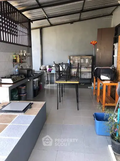 Spacious outdoor kitchen with modern appliances and ample seating area, perfect for entertaining guests.
