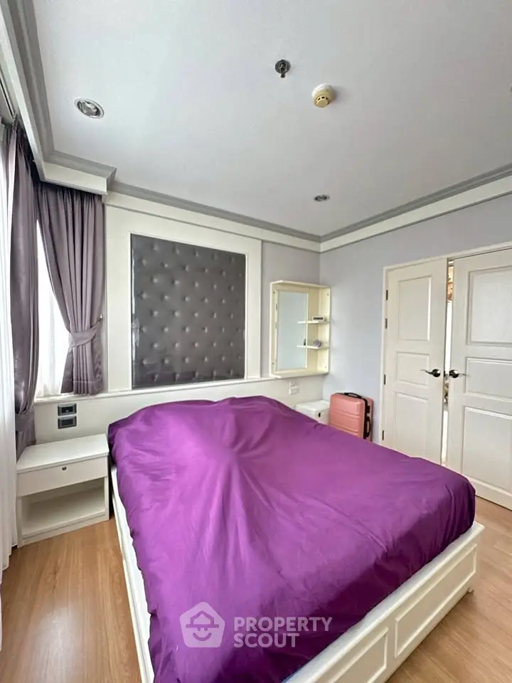 Spacious bedroom with elegant decor and natural light, featuring a plush bed and stylish furnishings.