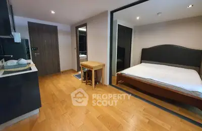 Modern bedroom with wooden flooring and sleek design in a contemporary apartment.