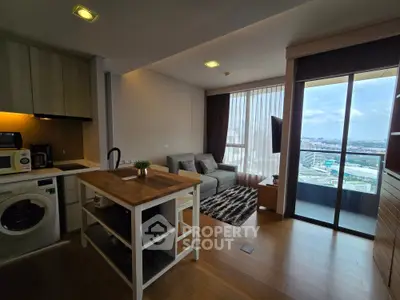 Modern open-plan living room with kitchen and balcony view in high-rise apartment