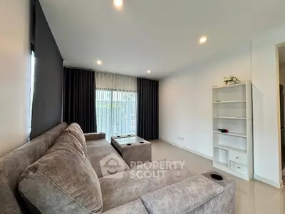 Spacious living room with modern gray sofa and large window for natural light.