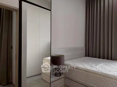 Modern bedroom with sleek design, featuring a comfortable bed and stylish lamp, perfect for relaxation.