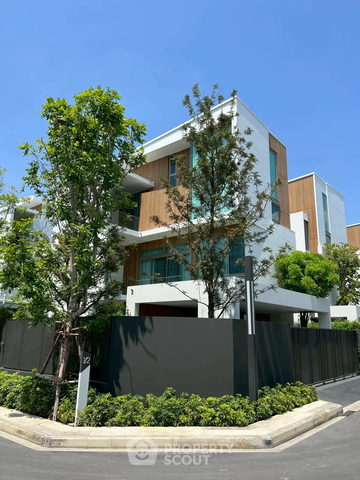 Modern luxury building with sleek design and lush greenery in prime location.