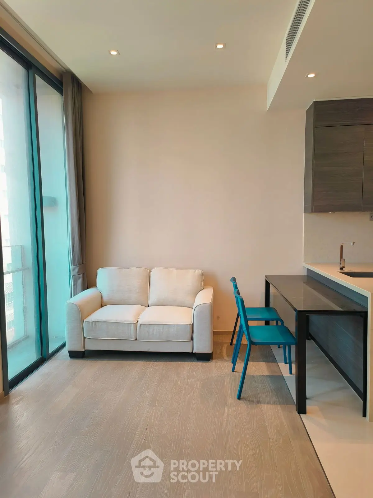 Modern living room with cozy sofa and dining area in open layout apartment.