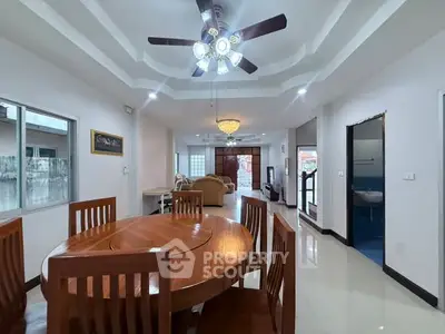 Spacious open-plan living and dining area with elegant ceiling fan and natural light.