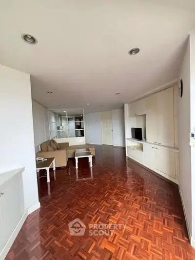 Spacious living room with parquet flooring and built-in cabinets