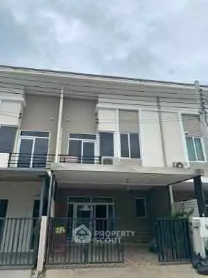Modern townhouse exterior with sleek design and spacious balcony.